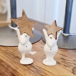 A tiny white resin santa holding a wooden star
