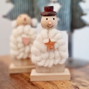 A wood and wool snowman with a top hat and a little wooden star