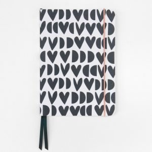 Geometric Hearts Notebook. An a5 notebook with a black and white geometric heart design cover from Caroline Gardner. Ruled pages a ribbon page marker and red elastic closure