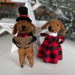 A pair of dog carol singers made from felt. One has a black top jat and a jacket and the other has a red and black checked dress