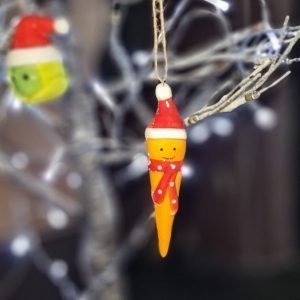 A cute ceramic hanging sprout in a santa hat and red and white spotty scarf
