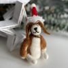A cute felt dog wearing glasses and a christmas santa hat