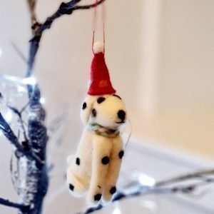 A black and white spotty felt dog wearing a red Christmas hatA hanging decoration for the Christmas tree