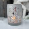 A silver votive with reindeer design.