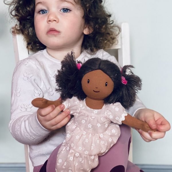 The most gorgeous rag doll with black hair brown skin and a beautiful pink layered dress.