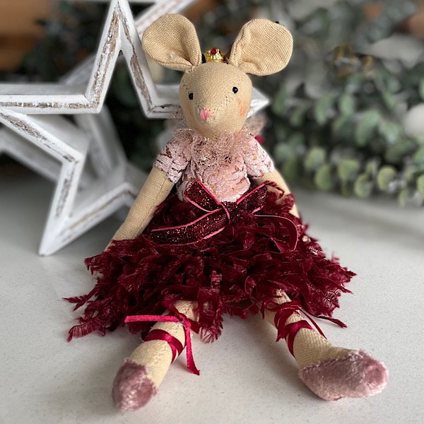 A sweet material mouse made from cotton and wearing a plum coloured feathered net dress