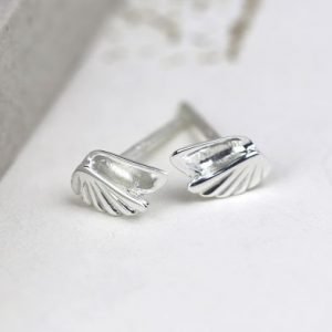 A pair of sterling silver stud earrings that are shaped like angel wings.
