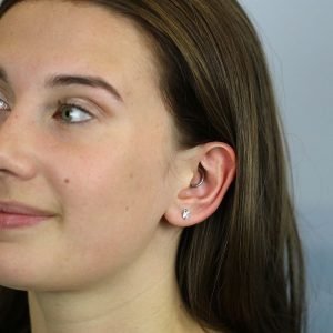 A pair of sterling silver stud earrings that are shaped like angel wings.