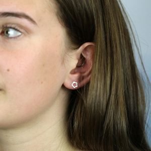 A pair of sterling silver stud earrings with a cutout flower design