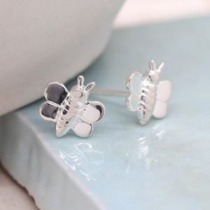 A pair of sterling silver stuff earrings that are shaped like tiny bumblebees.