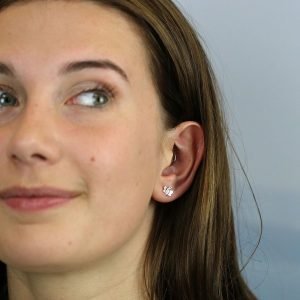 A pair of sterling silver stuff earrings that are shaped like tiny bumblebees.