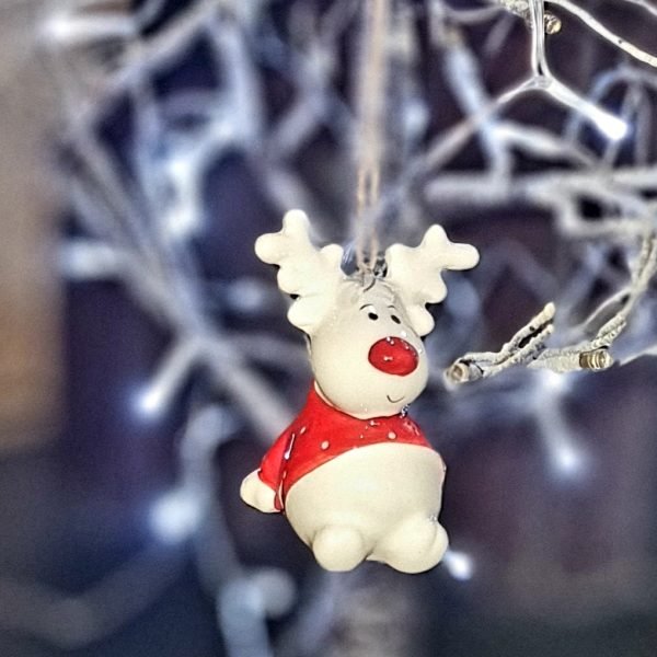 A cute ceramic sitting rudolf hanging decoration. White ceramic Rudolf with a red nose and a red and white spotted jumper