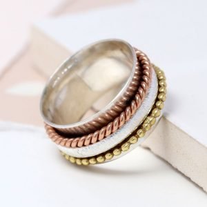 A lovely sterling silver ring with additional rose gold and gold plated spinning rings on it