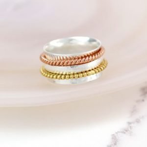 A lovely sterling silver ring with additional rose gold and gold plated spinning rings on it