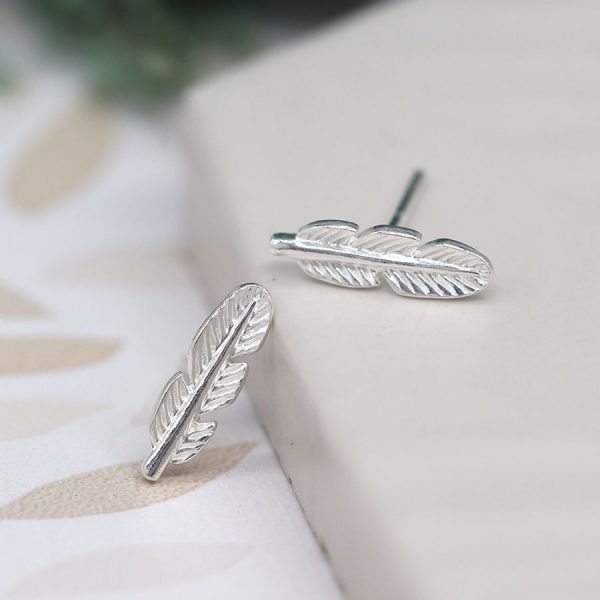 A pair of tiny sterling silver feather stud earrings