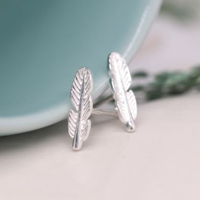A pair of tiny sterling silver feather stud earrings