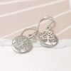 A pair of sterling silver drop earrings with a tree of life design.