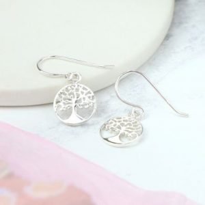 A pair of sterling silver drop earrings with a tree of life design.