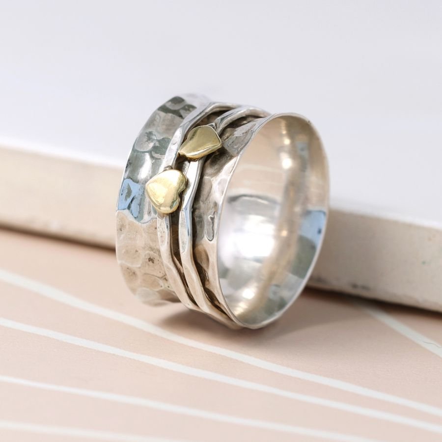 Sterling silver textured wide band ring with two small brass hearts on fine spinning bands