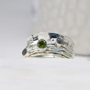 A sterling silver spinning ring with spinning bands set with moonstones and a peridot