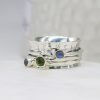 A sterling silver spinning ring with spinning bands set with moonstones and a peridot
