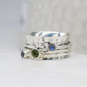 A sterling silver spinning ring with spinning bands set with moonstones and a peridot