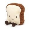 A cuddly toy made to look like a slice of toast with a happy smiley face and with chocolate coloured legs and feet.
