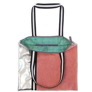 A shopper bag in coral velvet and faux silver and a black and white handle. The lining is teal sateen and a zip fastening