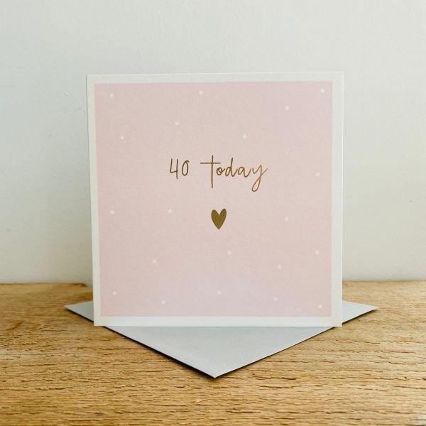 A square Pink card with gold dots and white hearts and the words 40 Today in gold print