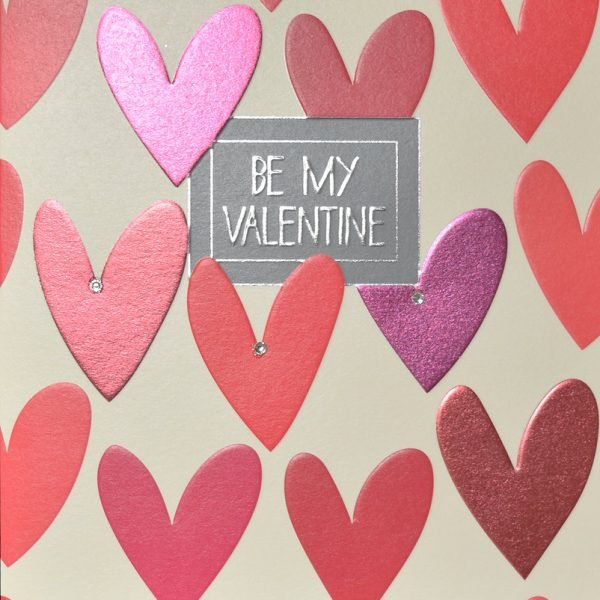 A lovely square card that is covered with red hearts which are finished with little diamante gems and a shimmer print effect. In the centre of the card is a little grey square with the words Be My Valentine printed in it.