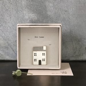 A lovely cardboard box card with a little wooden house inside it on the card and the words New Home printed on it.