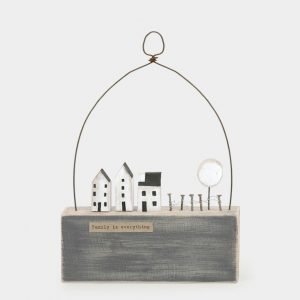 A lovely wooden scene with a blue block white wooden houses and a cute treem with a wire arch over it and the words Family is Everything printed on it.