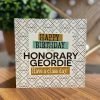 a geordie birthday card with a black and white geometric pattern and Happy Birthday to an honorary geordie have a class day printed over the top