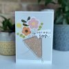 A card with a pale blue background and an image of a bunch of flweros with the words Get Well Soon printed on it.