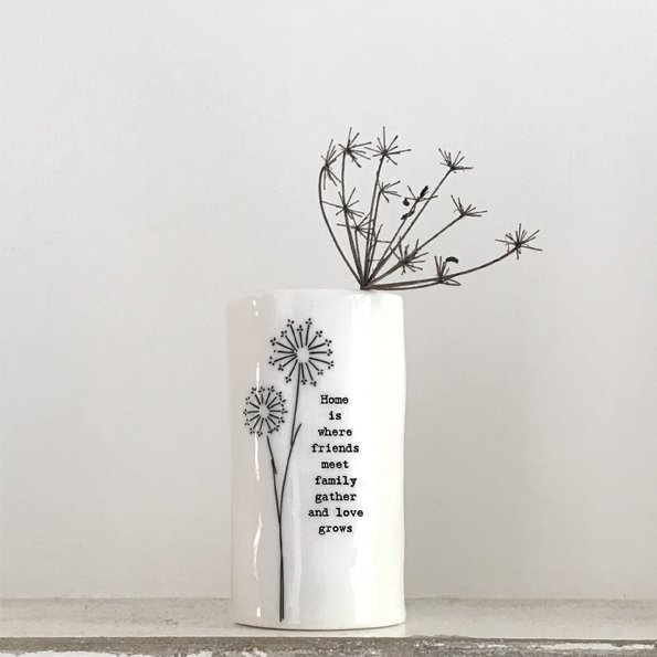 A lovely ceramic vase with an image f a dandelion on it and the words Home is where friends meet family gather and love grows on it.