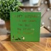 A green birthday card with happy birthday let's not count, the years, the calories, the bottles printed in gold foil