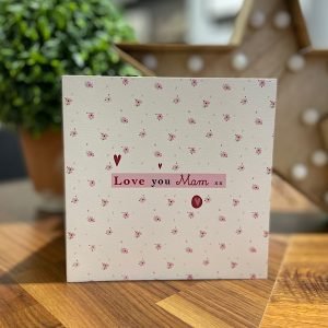 A card covered with little pink hears and Love you Mam printed on a pink block