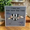 A grey card with I love you even more than Shearer only just printed on a grey background with shearer printed on a scroll across and black and white heart