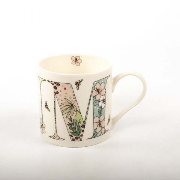 A sweet china mug with the word Mum in giant letters made up with a floral pattern around the mug.