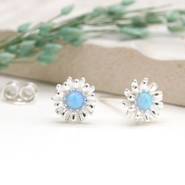 A beautiful pair of sterling silver flower stud earrings with a blue opal centre