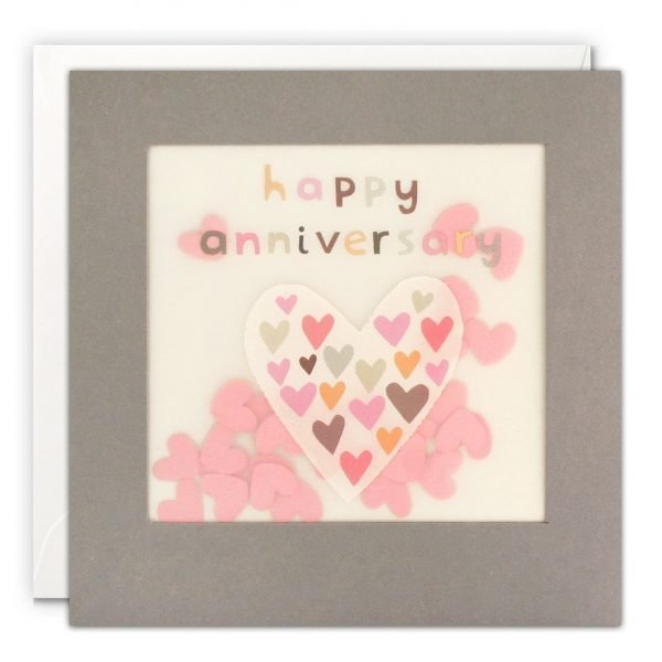 An anniversary card with a large heart filled with smaller colourful hearts. The message on the front reads 'happy anniversary' in colourful letters. The image is printed on translucent paper, showing pink paper confetti hearts behind. The confetti moves around when you shake the card.