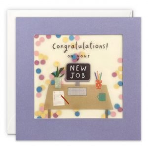 A new job card featuring a computer desk with colourful work accessories. The message on the front reads 'Congratulations! on your new job'. The image is printed on translucent paper, showing cream paper confetti dots behind. The confetti moves around when you shake the card. The card is purple