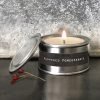 A sweet little tin candle with a label that says Peppered Pomegranate