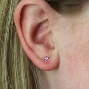 A pair of pink mini flower studs with crystal inset in the centre