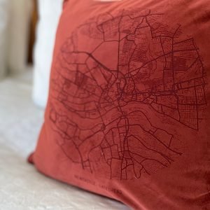A fabulous rust coloured velvet cushion with a map of Newcastle and Gateshead imprinted on it.