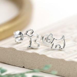 A pair of sterling silver stud earrings that are shaped like a scottie dog.