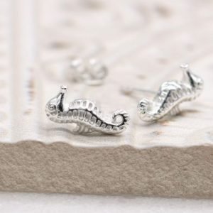 A lovely pair of sterling silver stud earrings that are shaped like seahorses.