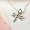 A silver dragonfly necklace with a silver link chain.