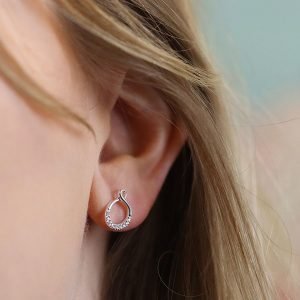 A pair of sterling silver infinity looped stud earrings with crystal studded effect.