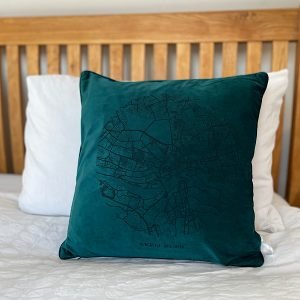A fabulous teal coloured velvet cushion with a map of Newcastle and Gateshead imprinted on it.